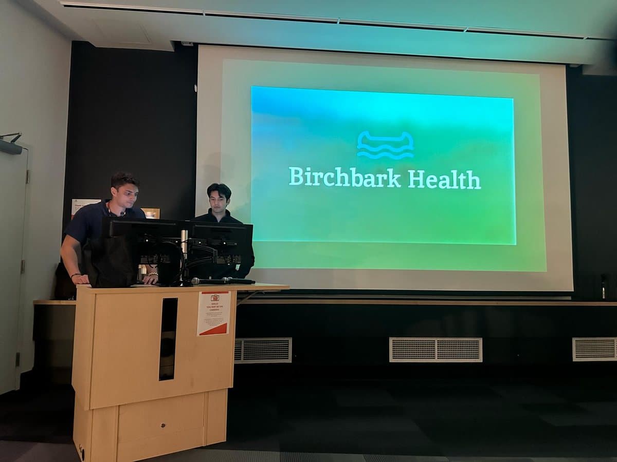 Two presenters sharing Birchbark Health's work in a lecture hall